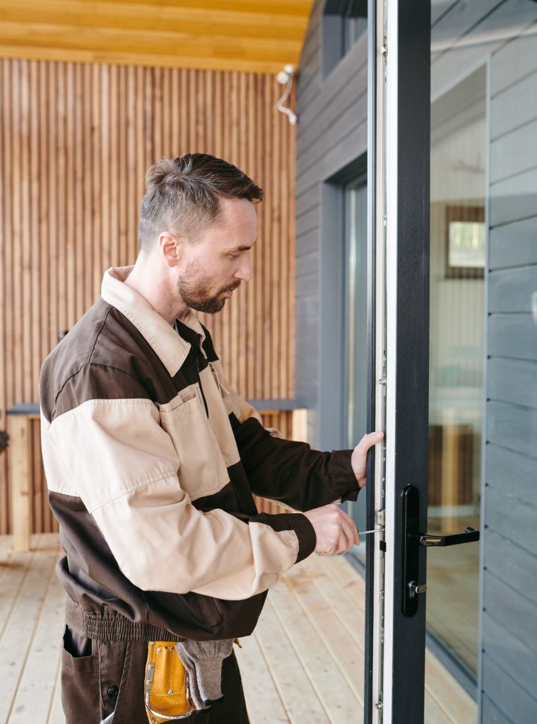 young-repairman-fixing-lock-in-large-transparent-door.jpg